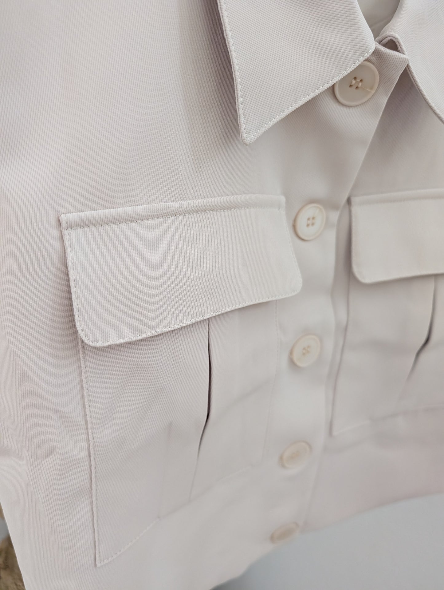 Ecru gillet met drukknopen en zakjes